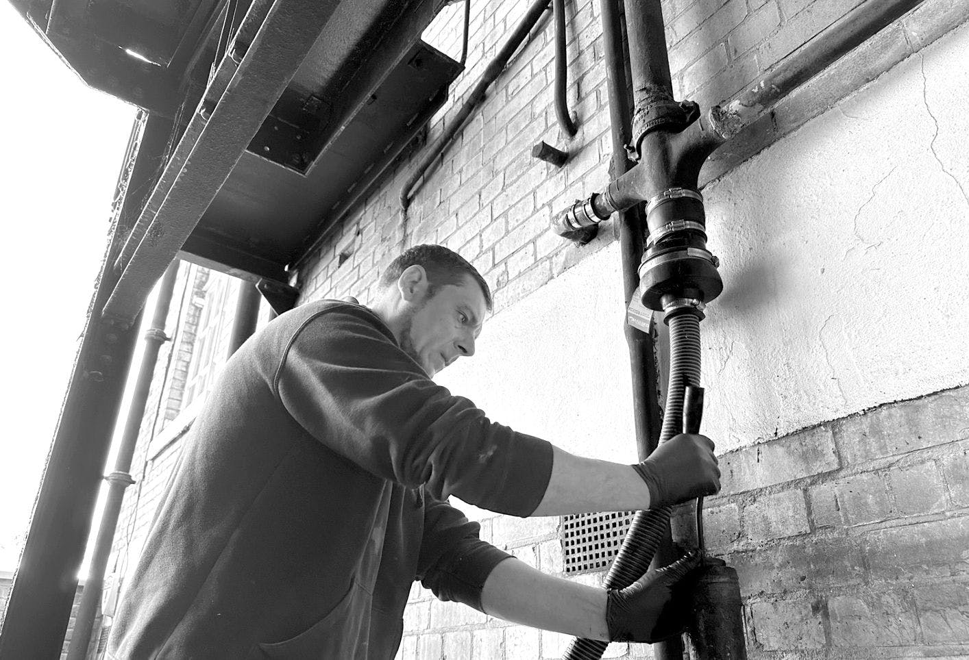 Man repairing cast iron waste pipes